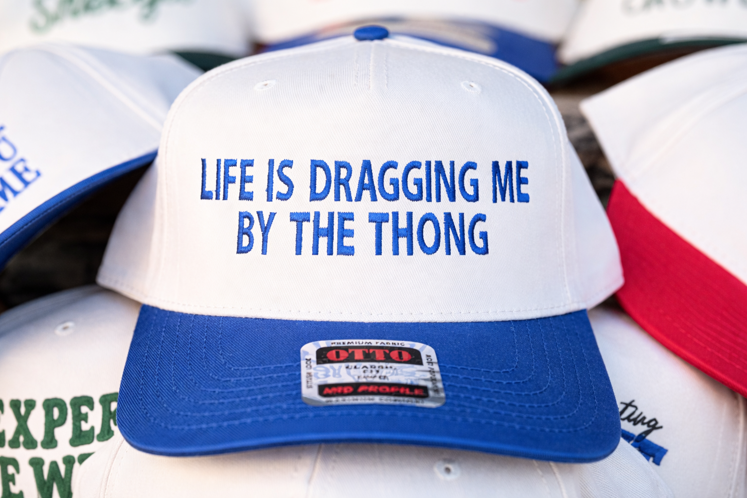 Life Is Dragging Me By The Thong OTTO Trucker Hat